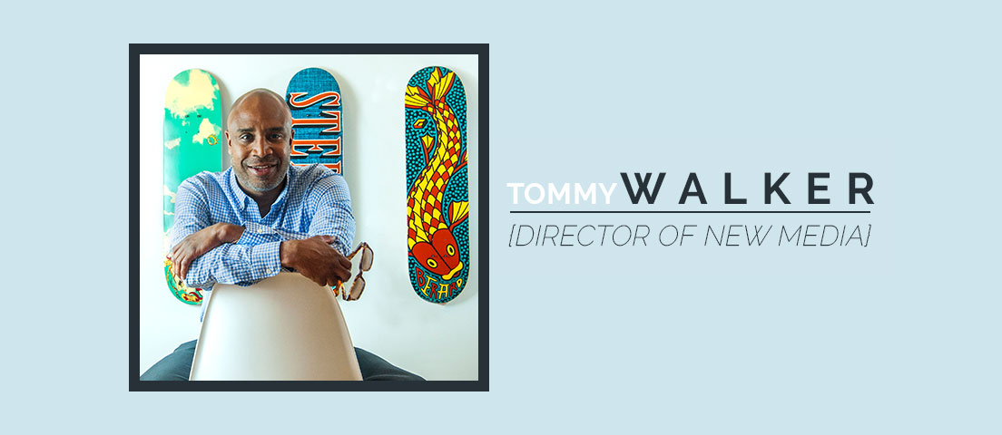 A man sitting in front of two skateboards.