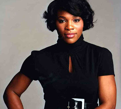 A woman in black shirt and belt posing for the camera.